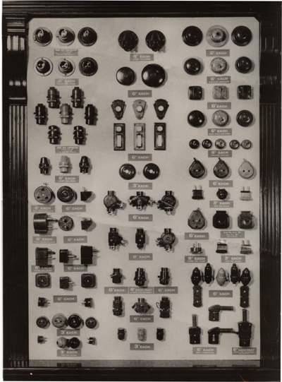 Back in the Thirties many poorer households were still lit with gas. Some had not invested in electricity at all.  Woolies offered a wide selection of electrical accessories, all made in bakelite, and all sixpence or less, as shown in this window display.  Click for a more detailed view in a new window.